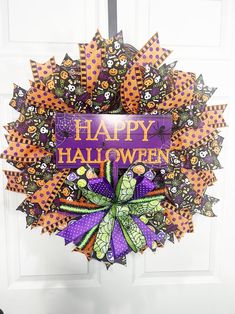 a purple and orange wreath with happy halloween written on it