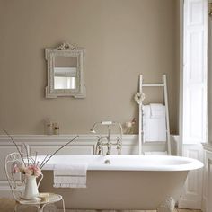 a white bath tub sitting next to a window with a blue decal on the wall