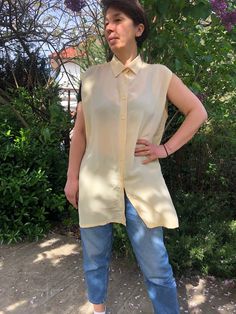 "Vintage 80-90ss sleeveless light yellow blouse. Front buttoned collared women's outfit. Side cut blouse. Summer women's clothing. Pure silk blouse. Pacific Line label. L size. From shoulder to shoulder  18\" 46cm Bust  48\" 122cm Length  34\" 86cm. Little hole on back side. See on photos." Classic Sleeveless Blouse For Spring, Vintage Beige Blouse For Day Out, Classic Sleeveless Summer Shirt, Classic Beige Blouse For Summer, Vintage Yellow Sleeveless Top, Sleeveless Spring Daywear Shirt, Spring Sleeveless Blouse, Vintage Sleeveless Tops For Day Out, Classic Beige Sleeveless Top