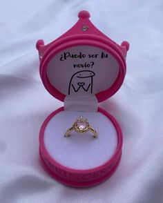 a pink ring box with a diamond in it