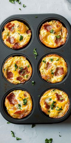 mini pizzas in a muffin tin with cheese and bacon on top, ready to go into the oven