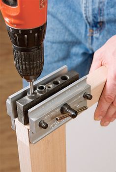 a person using a drill to attach a piece of wood