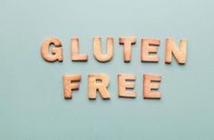 the word gluten free spelled with wooden letters on a light blue background to spell out gluten free