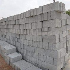 a man standing next to a pile of cement blocks