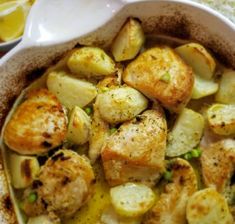 a dish with potatoes, peas and rice on a table next to lemon wedges