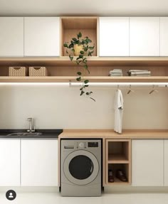 a washer and dryer in a small room with cabinets on the wall behind it