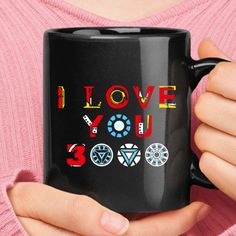 a woman holding a black coffee mug with i love you 3 0 written on it