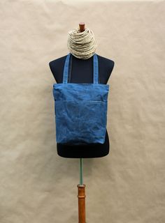 a blue tote bag sitting on top of a mannequin's head