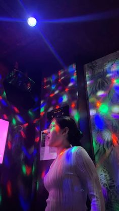 a woman standing in front of colorful lights