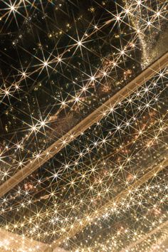 an aerial view of the city at night with stars and lights in the sky above