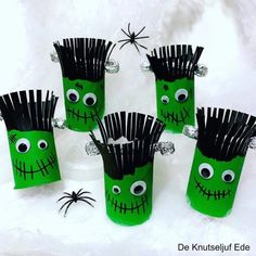 four green cups with black hair and eyes on them, each decorated to look like a spooky monster