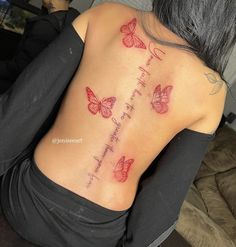 the back of a woman's upper body with butterflies on it and words written in cursive writing