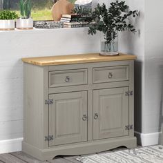 a grey sideboard with two drawers and a potted plant on the top shelf