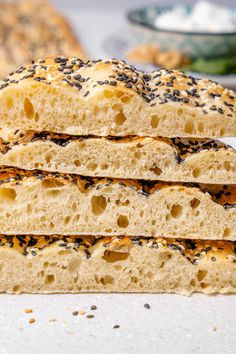 four sesame seed bagels stacked on top of each other