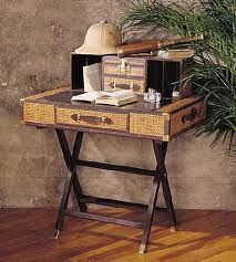 an old desk with a hat on top and other items sitting on it next to a potted plant