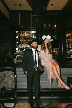 a man and woman standing next to each other in front of a bar