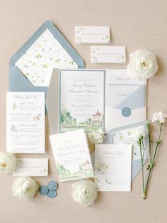 the wedding stationery is laid out with flowers