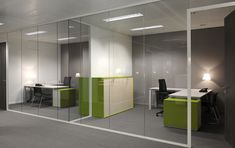 an office with glass walls and desks in the middle is shown, as well as two green cubicles