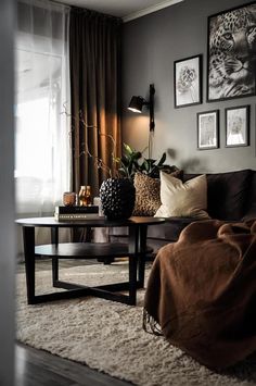 a living room with a couch, coffee table and pictures on the wall above it