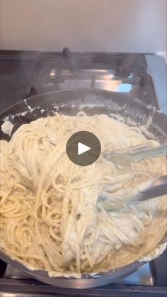 a pan filled with pasta being cooked on top of an open stove burner,