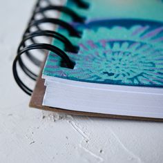 an open spiral notebook on a white surface