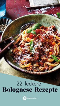 a bowl filled with spaghetti and sauce on top of a table