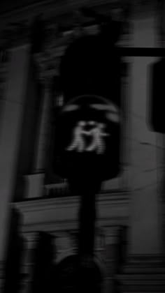 a black and white photo of a clock tower in the dark with blurry background