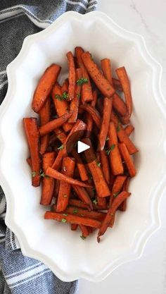 a white bowl filled with carrots on top of a table