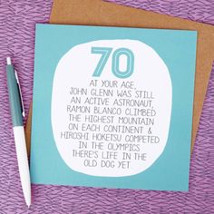 a card with the words 70 on it and a pen next to it, sitting on a purple surface