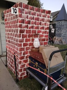 a pile of luggage sitting on top of a cart next to a red brick wall