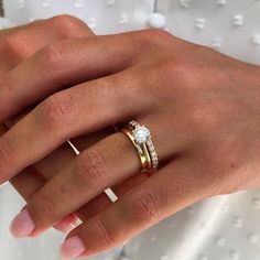 a woman's hand with two rings on it and one ring in the middle