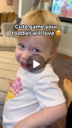 a little boy that is sitting down with a smile on his face and the caption says, cute game your todder will love