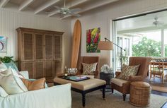 a living room filled with furniture and a surfboard mounted to the side of the wall