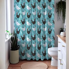 a bathroom with a shower curtain that has chickens on it and plants in the corner