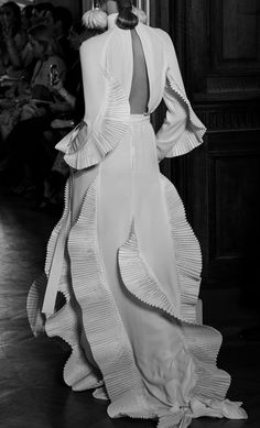 a black and white photo of a woman in a dress with ruffles on it