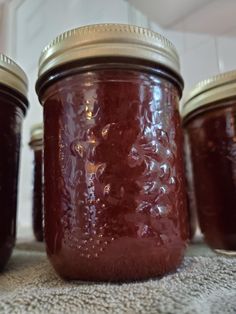 several jars filled with jam sitting on top of a carpeted floor next to each other