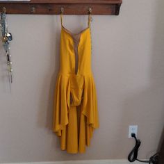 a yellow dress hanging on a wall