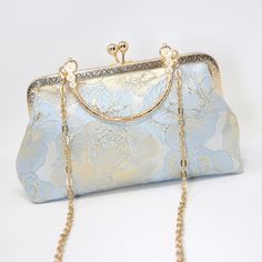 New to our Millennium collection, This beautiful romantic Light Blue Shimmering Gold Rose FLORAL bridal clutch bag is made of very fine quality of fabric and metal and it comes with a long Detachable metal chain for your Big day! Dimensions- length oh the bag is 5.5 inches and width of the bag is 9 inches. Gold Metal chain about 44 inches long. ► ABOUT YOUR ORDER * All items are neatly packaged in our beautiful jewelry boxes and elegant organza bags. * All items are 100% gift-ready. * Each order comes with a personalized handwritten card and a branded Millennium Bride jewelry cloth. * Each order comes with a free gift. ► PERSONALIZTION * If your order is a gift, you may contact us with the recipient's name or a message, and we'll print a personalized card that will be elegantly packaged wi Blue Clutch Bag For Wedding, Blue Wedding Clutch Bag, Wedding Shoulder Bag With Detachable Strap, Blue Handheld Clutch For Wedding, Elegant Blue Shoulder Bag For Wedding, Blue Handheld Bags For Wedding, Blue Handheld Bag For Wedding, Blue Clutch Evening Bag For Wedding, Gold Evening Bag With Detachable Strap For Wedding