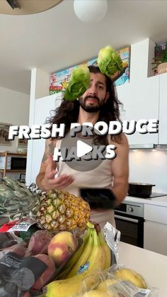 a man with long hair standing in front of a counter filled with fruits and vegetables