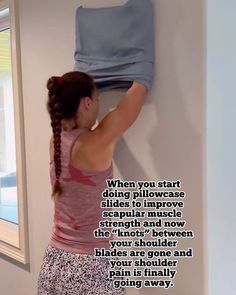 a woman hanging on to the wall with her arms and legs in front of her head