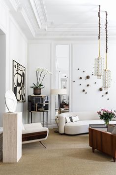 a living room filled with white furniture and lots of decor on top of carpeted flooring