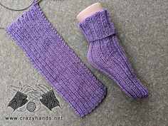 a pair of purple knitted mittens sitting on top of a gray floor next to a pair of glasses