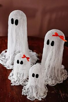 three white ghost decorations sitting on top of a table