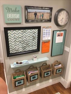 a wall with pictures and other items on it, including framed pictures above the shelf