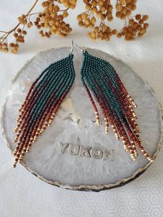 a pair of beaded earrings with the word tokyo on it