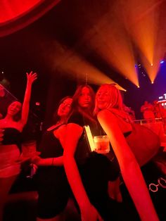 two women standing next to each other in front of a crowd at a club or nightclub