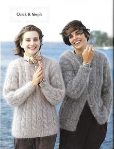 two women standing next to each other in front of the ocean with their hands together