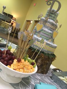 a bowl filled with grapes and cheese on top of a table next to other food items