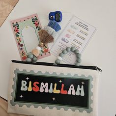 there is a small bag with some items on it that say bismalah and beads