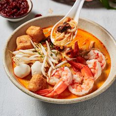 a bowl of soup with shrimp, scallops and croutons